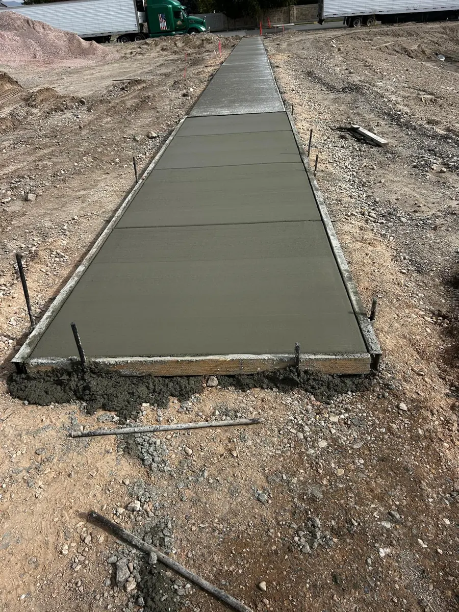 New concrete walkway extending through a prepared site