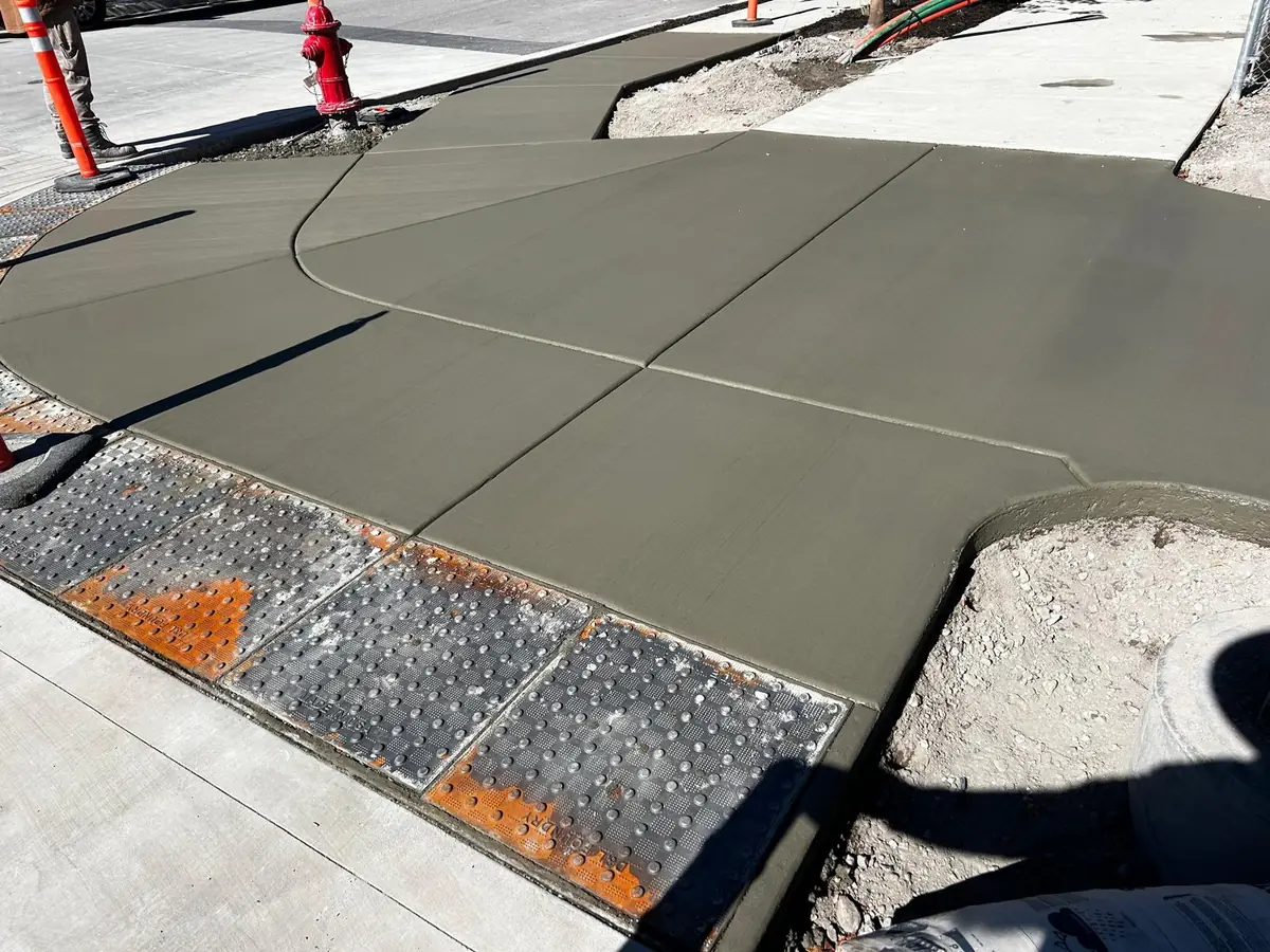 Fresh concrete corner and curb ramp with tactile paving
