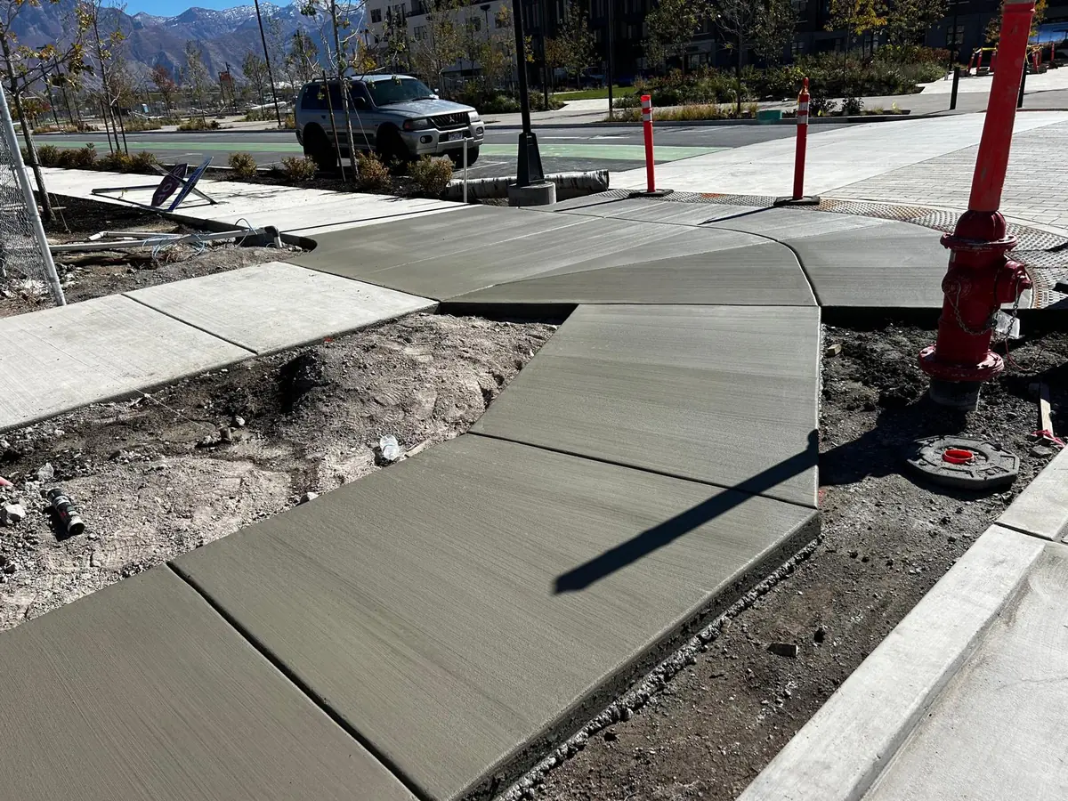 New concrete sidewalk and curb approach at a street corner