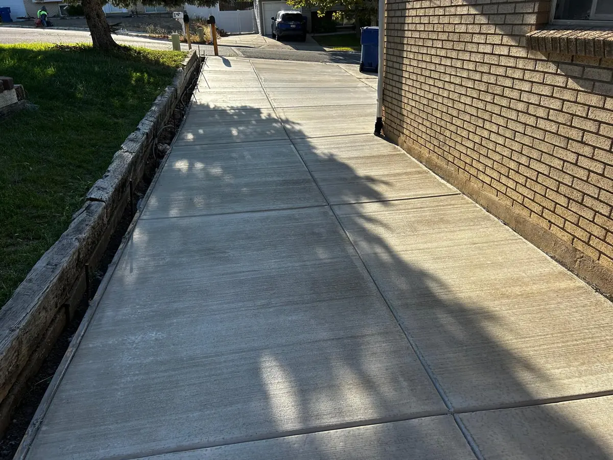 Concrete path running beside a brick home