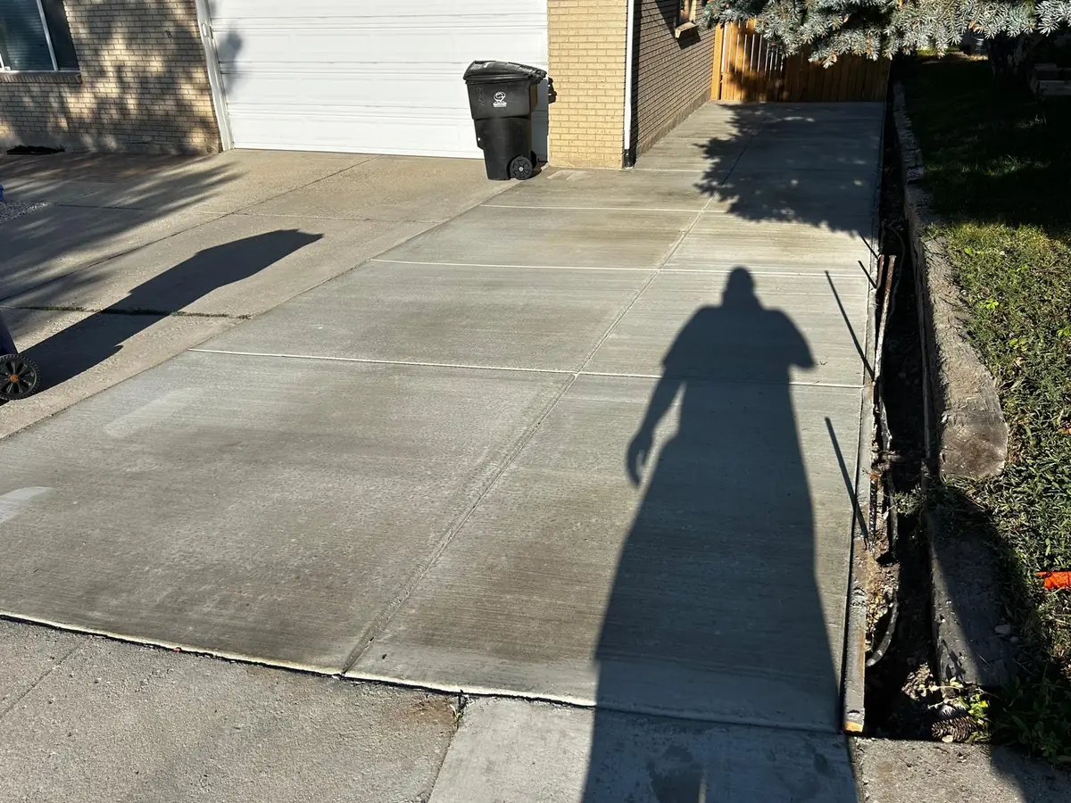 Broom-finished driveway with a continuous path beside the home