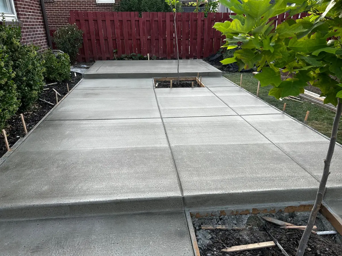 Finished concrete patio with clean joints and defined planting areas