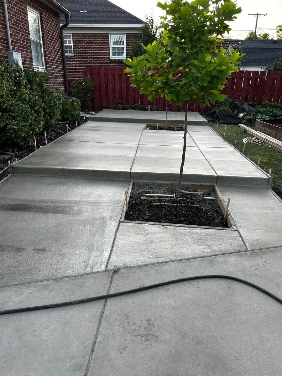 Concrete patio and garden path beside a brick home