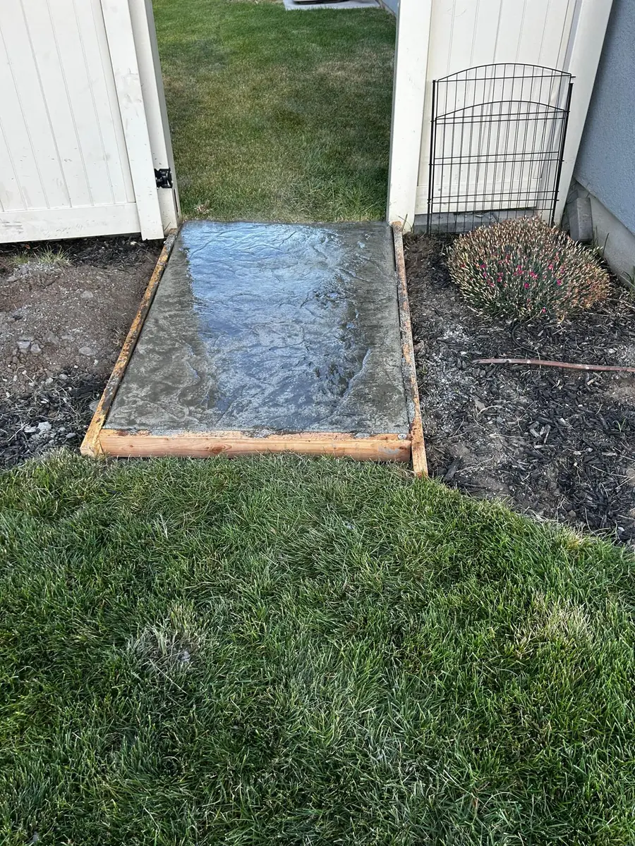 Textured concrete landing at a backyard gate