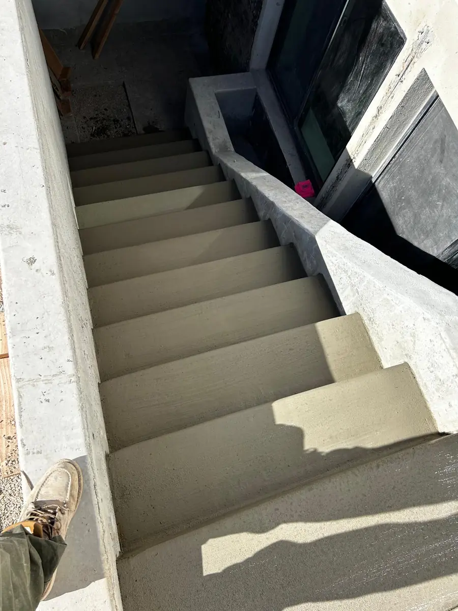 Concrete exterior stairs and landing beside the house