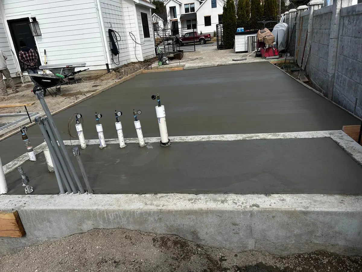 Concrete flatwork extending along a fenced residential yard